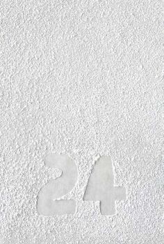 the number twenty four is written in white powder on a surface that looks like snow