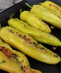 green peppers with seasoning on them in a black pan, ready to be cooked