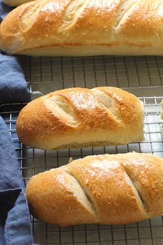 three loaves of bread sitting on top of a cooling rack next to each other