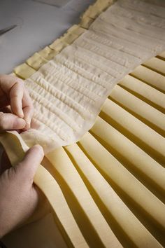 a person is cutting up some material on a piece of paper that has been cut into strips