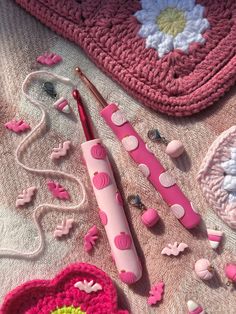 a pink crocheted bag and some knitting supplies