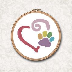 a cross stitch heart with paw prints on it