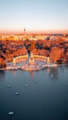 an aerial view of a lake with trees and buildings in the background