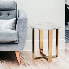 a living room with a gray couch and marble table on the floor next to it