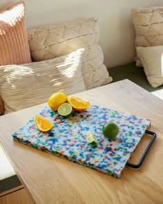 there are lemons and limes on the table in front of the couches