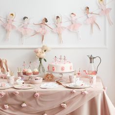 a table topped with pink cakes and cupcakes