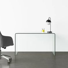 an office chair sitting next to a glass table