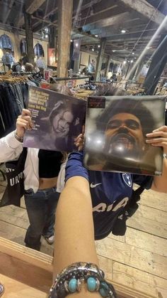 a person holding up a magazine with a man's face on it in front of them