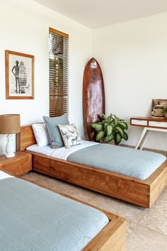 a bedroom with two beds and a surfboard on the wall