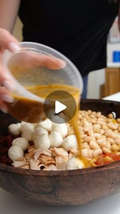 someone is pouring sauce on some food in a bowl