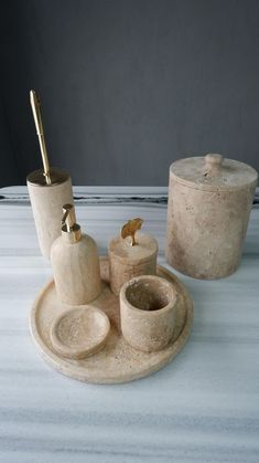 a white table topped with two cups and saucers next to a container filled with salt and pepper