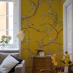 a living room with yellow walls and floral wallpaper