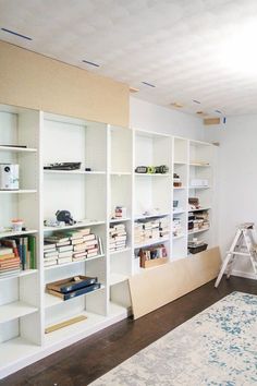 a room with white shelving and shelves filled with books