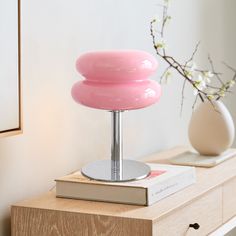 a pink lamp sitting on top of a wooden table