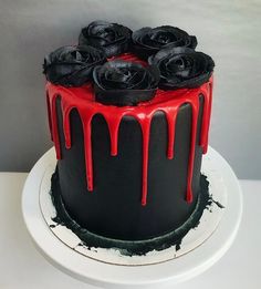 a black and red cake with roses on top