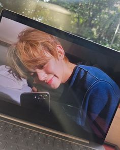 a laptop computer sitting on top of a desk with a photo of a young man