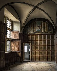 an old building with wood paneling and arched doorway leading to another room in the house