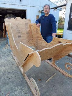 a man standing next to a wooden sleigh