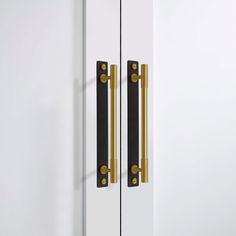 an image of a door handle on the side of a white cabinet with gold handles