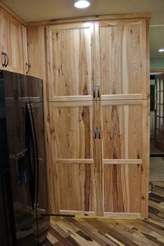 a kitchen with wooden cabinets and black refrigerator