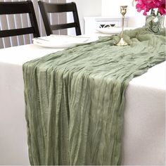 the table is set with two chairs and a green table cloth draped over it's edge