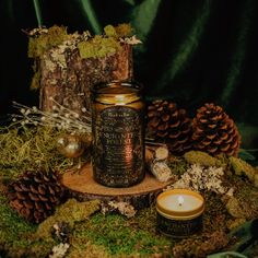 a candle and some pine cones on a table