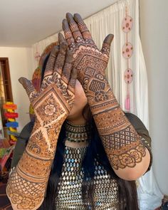 a woman with her hands on her face covered in hendix and holding her hands up to her face