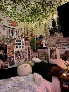 a bedroom with many pictures and plants hanging from the ceiling