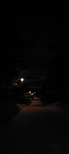 an empty road at night with street lights