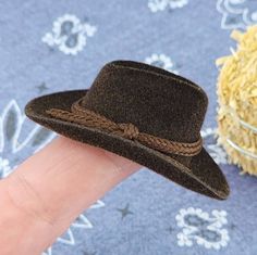 "This little brown cowboy hat will be the perfect accent for your dollhouse, diorama, miniature barn, saloon, and western scenes!  It can be hung on the back of a chair, on the wall, or even placed on a bale of straw. The possibilities are endless!  This is a miniature display item and, therefore, may not fit your doll. Please see the measurements before purchasing for that reason. The hat measures approximately: 1 5/8\" Wide 2\" Long 3/4\" Tall Inner circumference measures approximately: 3/4\" Handmade Western Brown Mini Hats, Handmade Western Mini Hats In Brown, Handmade Brown Mini Fedora Hat, Dollhouse Diorama, Brown Cowboy Hat, Old Western, Sevierville Tn, Straw Bales, Miniature Display