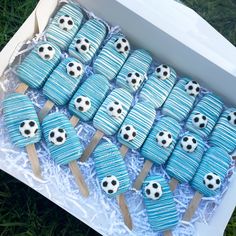 a box filled with cupcakes covered in blue frosting and soccer ball decorations