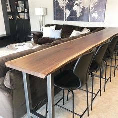 a living room filled with furniture and a long wooden table in front of a couch