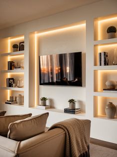 a living room filled with furniture and lighted shelves