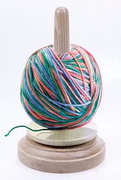 a ball of yarn sitting on top of a wooden stand