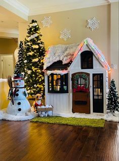 a christmas scene with a snowman and a dog house in front of a tree