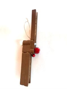 a piece of cardboard is tied up with string and some red pom - poms