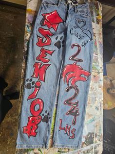 senior pictures outfit idea Airbrush Senior Pants, Senior Jeans Red White Black, Senior Jeans Black And Gold, Grad Coveralls Ideas, Senior Canvas Ideas, Blue And Gold Senior Jeans, Senior Jeans Spiderman, Senior Drawing Ideas, Senior Pants Ideas Paint