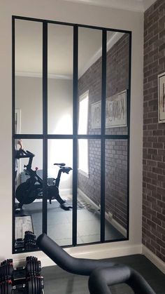 a gym room with exercise equipment in the background and a mirror reflecting it's reflection