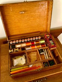 an open wooden box filled with lots of crafting supplies