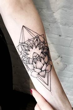 a woman's arm with a flower tattoo on it