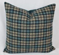 a green and brown plaid pillow on a white background