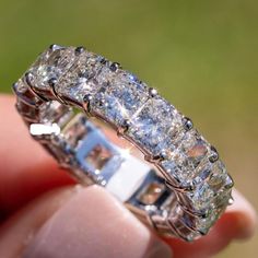 a close up of a person holding a ring with many diamonds on the inside of it