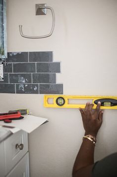 a person is measuring the wall with a tape measure