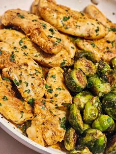 chicken and brussel sprouts are served in a white bowl on the table