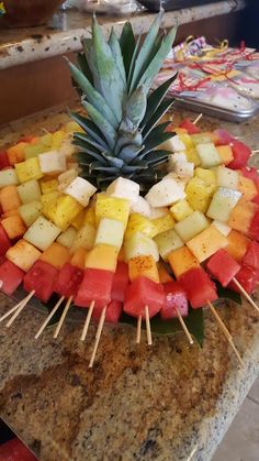 a pineapple and watermelon on skewers in the shape of a circle