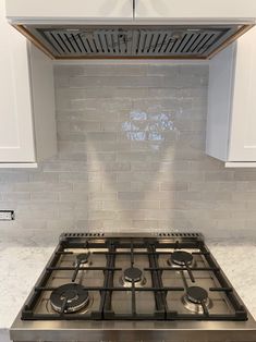 a stainless steel stove top in a white kitchen