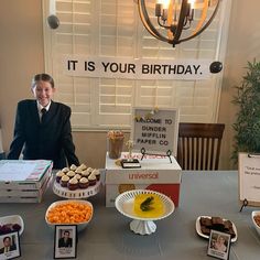 a man standing in front of a table filled with desserts and candies on it