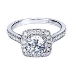 a white gold engagement ring with an intricate halo setting and pave set diamonds on the band