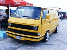 a yellow van parked next to a red tent