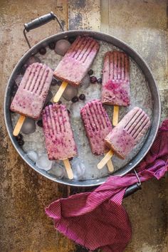 popsicles with blueberries and ice are in a pan